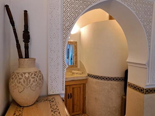 a hallway with a vase and a mirror in a room at Dar Kleta in Marrakesh