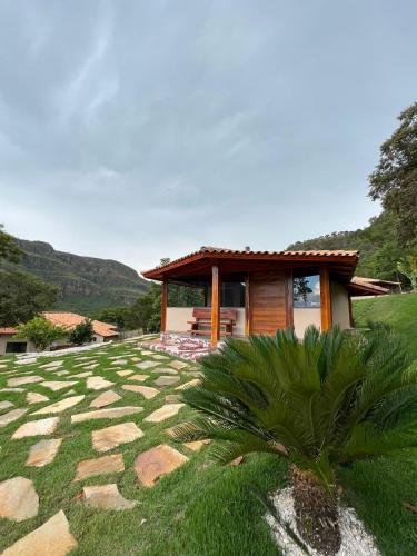a house with a stone yard with a building at Pousada Jipe Canastra in Capitólio