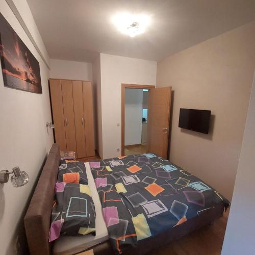 a bedroom with a bed with a colorful quilt at Apartman Ana Alibi 1 in Zlatibor