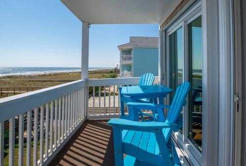 a balcony with blue chairs and a view of the beach at Large Oceanfront condo in a quiet section of Carolina Beach Rentals in Carolina Beach