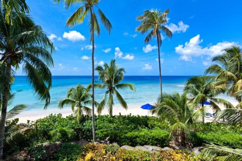 Blick auf einen Strand mit Palmen und das Meer in der Unterkunft Schooner Bay 207 by Blue Sky Luxury in Saint Peter