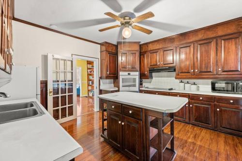 a kitchen with wooden cabinets and a ceiling fan at Fully Restored Country Manor in Baldwin
