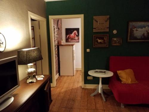 ein Wohnzimmer mit einem roten Sofa und einem Tisch in der Unterkunft Staffel`s Hob in Oberrosphe