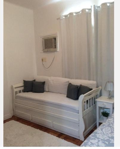 Sofá blanco en un dormitorio con ventana en Lindo Studio Ipanema, en Río de Janeiro