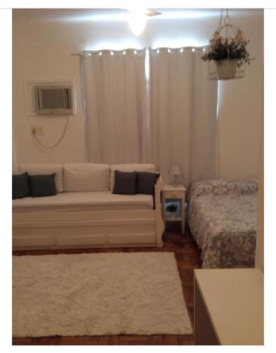 a living room with a couch and a bed at Lindo Studio Ipanema in Rio de Janeiro