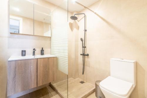 a bathroom with a shower and a toilet and a sink at Elegant Suite 1 near the Beach in Ayía Marína