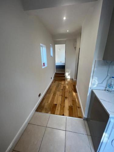 a hallway of a house with a wooden floor at Green lanes N8, Studio flat! in London
