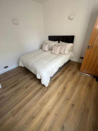 a white bed in a room with a wooden floor at Green lanes N8, Studio flat! in London