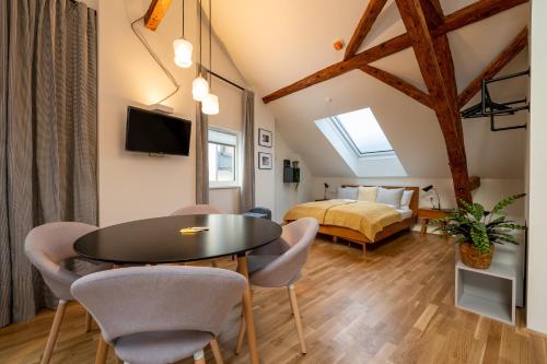 Zimmer mit einem Tisch, Stühlen und einem Bett in der Unterkunft NOAS Home in Innsbruck