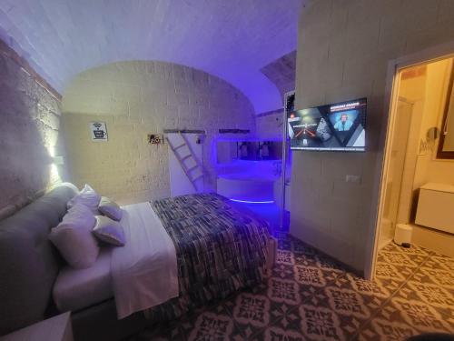 a bedroom with a bed and a tv in a room at QUART0 GREC0 Suite 17 in Altamura