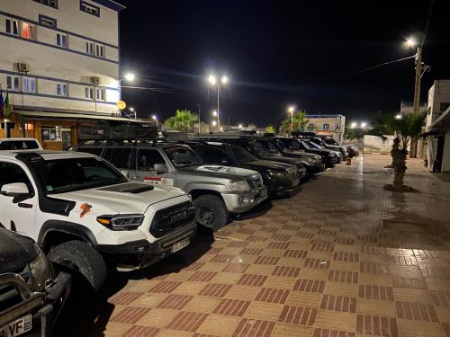 a row of cars parked in a parking lot at night at Hotel Dubai in Tan-Tan Plage
