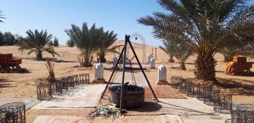 a ceremony in the desert with chairs and a barrel at Sables Chaud Camp in Adrouine
