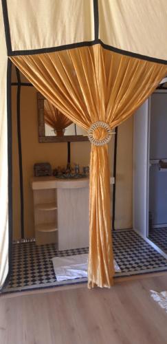 a curtain in a room with a kitchen at Sables Chaud Camp in Adrouine