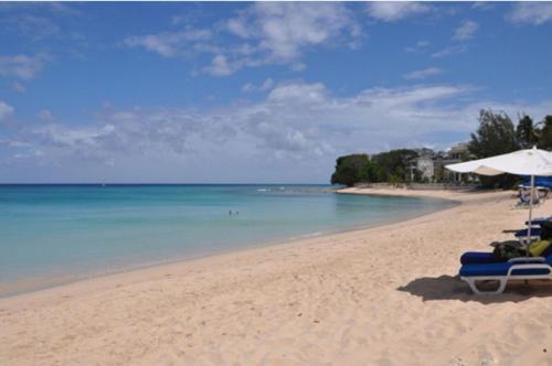 a beach with chairs and an umbrella and the ocean at Bora Bora by Blue Sky Luxury in Saint James