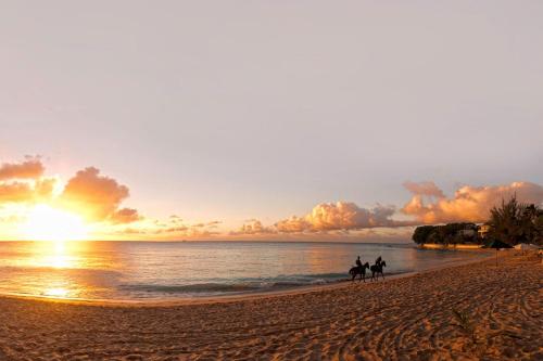 聖詹姆斯的住宿－Bora Bora by Blue Sky Luxury，日落时分在海滩上骑马的两人
