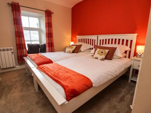 a bedroom with a large bed with red walls at 3 South View in Horton in Ribblesdale