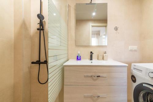 a bathroom with a sink and a washing machine at Elegant Suite 2 near the Beach in Ayía Marína
