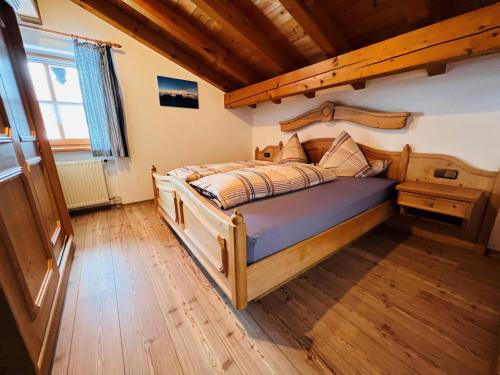 a bedroom with a wooden bed with a wooden floor at Haus am Dürrach in Reit im Winkl