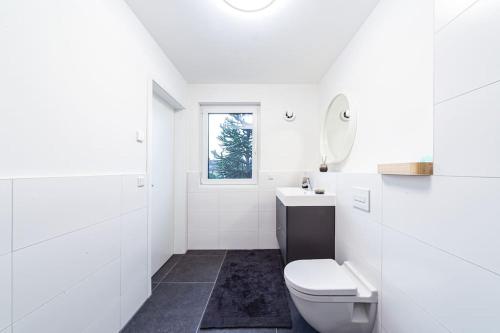 a white bathroom with a toilet and a sink at A&V Apartments Wunderschöne Penthouse Wohnung in Moers