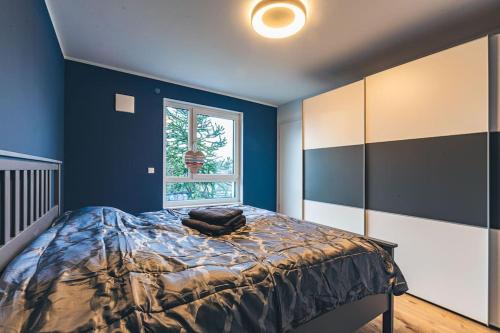 a blue bedroom with a bed and a window at A&V Apartments Wunderschöne Penthouse Wohnung in Moers