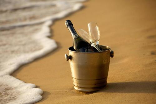 Un cubo en la playa con una botella de champán y utensilios. en Footprints by Blue Sky Luxury, en Saint James