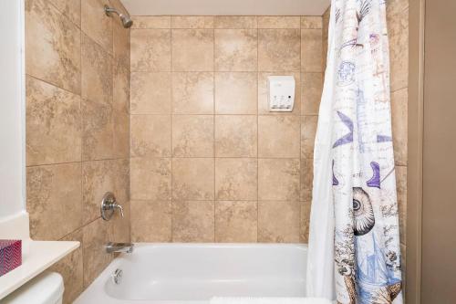 La salle de bains est pourvue d'une baignoire et d'un rideau de douche. dans l'établissement Entire Condo Downtown, near BMO & Saddle Dome, free Parking, 1,5 hrs to Banff, à Calgary