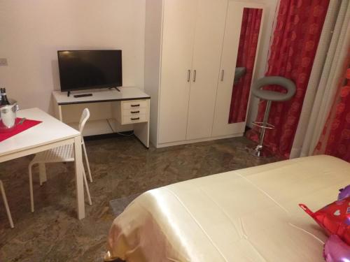 um quarto com uma cama e uma secretária com uma televisão em Executive center rooms em Bari