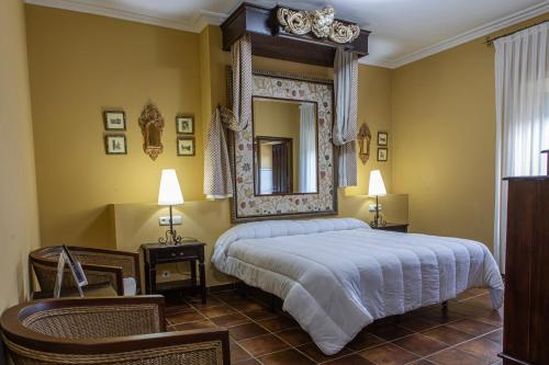 una camera con un grande letto e uno specchio di DON JULIO a Perales del Puerto