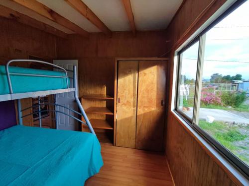 Habitación pequeña con litera y ventana en Cabañas Rayen Karu, en Puerto Montt