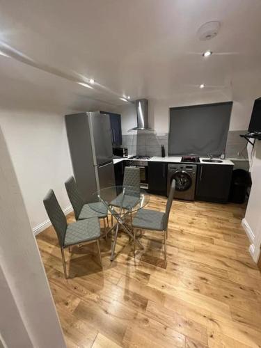 sala de estar con mesa de cristal y sillas en 2 bedroom apartment in HampdenRd, en Londres