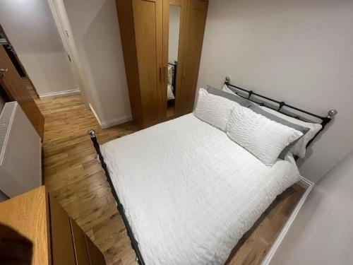 a bed with white sheets and pillows in a room at 2 bedroom apartment in HampdenRd in London