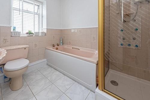 a bathroom with a tub and a toilet and a shower at Ger y Bae sleeps 12 in Cemaes Bay