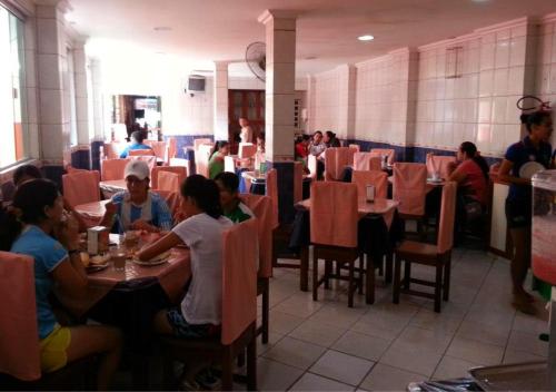 eine Gruppe von Personen, die in einem Restaurant an Tischen sitzen in der Unterkunft Hotel Paraiso Belém in Belém