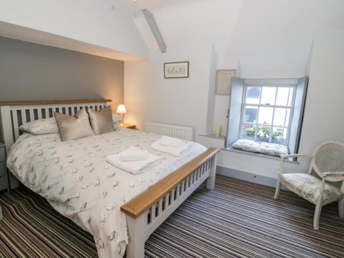um quarto com uma cama grande e uma janela em Sea Chest em Conwy
