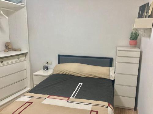 ein kleines Schlafzimmer mit einem Bett und einer Kommode in der Unterkunft Magnífico Apartamento en el Centro de Puigcerdá in Puigcerdà
