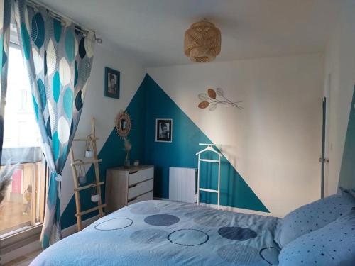 a blue and white bedroom with a bed and a window at Appart hyper centre- Parking in Vierzon