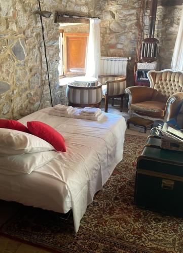 Un dormitorio con una cama y una pared de piedra. en Il Fiore di Montieri, en Montieri
