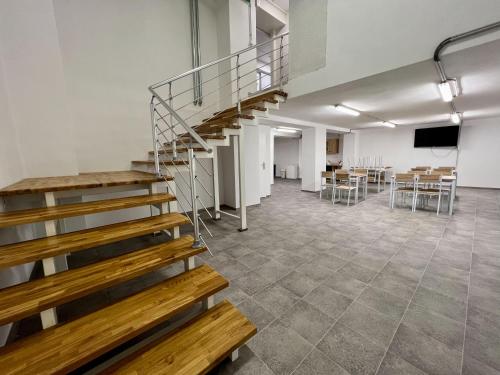 a staircase in a room with a table and chairs at Hostel H18 in Bardejov
