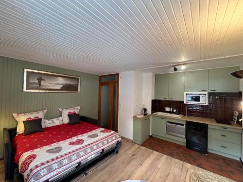 une chambre avec un grand lit et une cuisine dans l'établissement STUDIO DENT DU CAIMAN, CHAMONIX hyper CENTRE, PARKING, VUE MONT BLANC, à Chamonix-Mont-Blanc