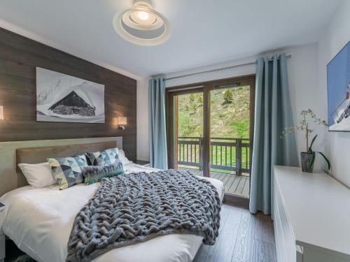 une chambre avec un lit et un balcon dans l'établissement Appartement moderne avec jacuzzi extérieur et terrasse à Courchevel - FR-1-563-106, à Courchevel