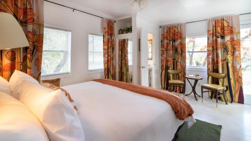 ein Schlafzimmer mit einem großen weißen Bett und Fenstern in der Unterkunft Baby Owl Lakehouse in Canyon Lake