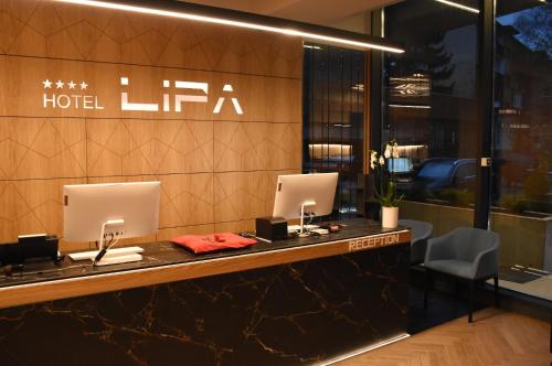 a hotel reception desk with two computers on it at Lipa Hotel in Travnik
