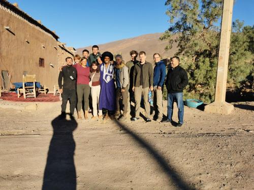 a group of people posing for a picture with their shadow at Bivouac Les Nomades & Foum zguid to chegaga tours in Foum Zguid