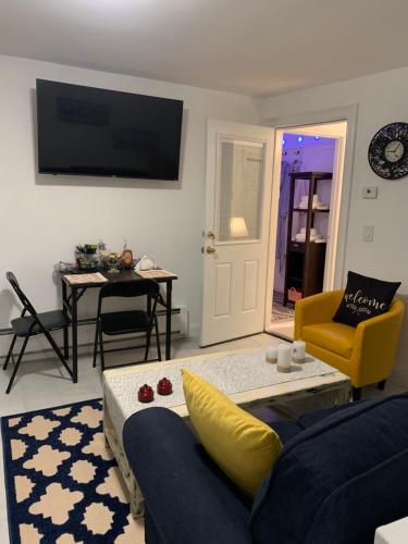 a living room with a blue couch and a yellow chair at Comfy and Chic Boston Apartment! in Boston