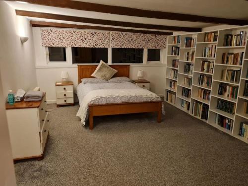 a bedroom with a bed and book shelves at The Hillock in Uplawmoor