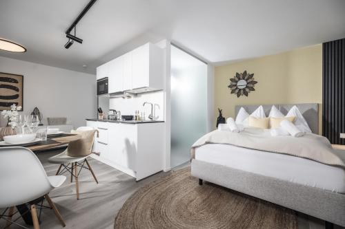 a bedroom with a large bed and a kitchen at MaxStudio Premium Apartment Zillertal mit Bergblick in Schlitters