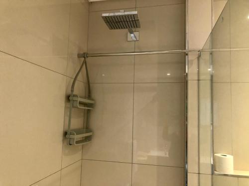 a shower with a glass door in a bathroom at Urban Awe Apartment: iTowers 21st Floor in Gaborone