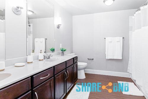 a bathroom with a sink and a toilet and a mirror at Dallas Business Suite - Petremote Work in Dallas