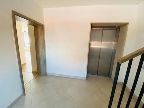 an empty hallway with a elevator and a door at Enzian by Mountain ways in Loučná pod Klínovcem