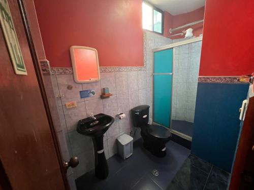 baño con aseo negro y lavamanos en Casa de Lewis, en Puerto Baquerizo Moreno